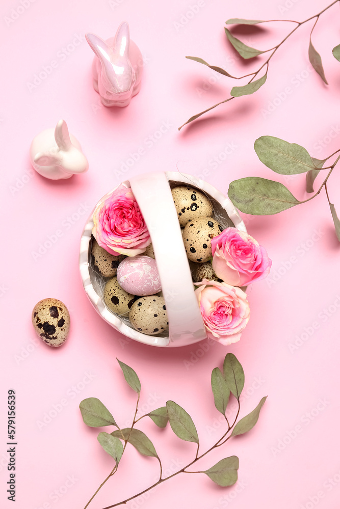 Basket with Easter quail eggs, rose flowers, eucalyptus branches and bunnies on pink background Basket with Easter quail eggs, rose flowers, eucalyptus branches and bunnies on pink background