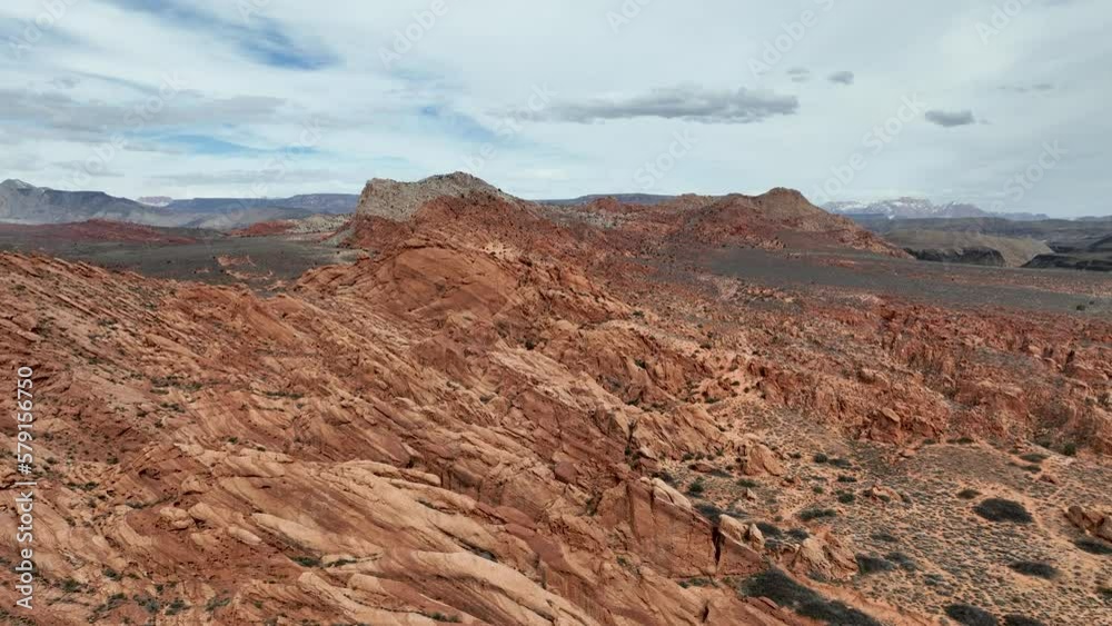Aerial desert red rock ridge Virgin River valley Utah fast. Southwestern desert near St George. Red stone and black volcanic mountain landscape. Geological landscape wind and water erosion. Aerial desert red rock ridge Virgin River valley Utah fast. Southwestern desert near St George. Red stone and black volcanic mountain landscape. Geological landscape wind and water erosion.