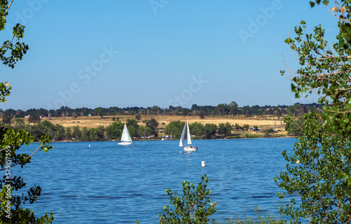 A view of the Reservoir at Cherry Creek State Park in Summertime through the cottonwoods that line the trails by the lakeside. Park is located in Arapahoe County, Colorado close to Denver.
