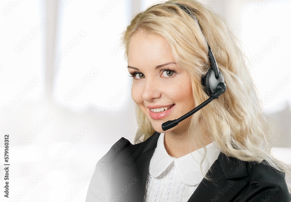 Young woman working wearing a headset in a call centre. Young woman working wearing a headset in a call centre.