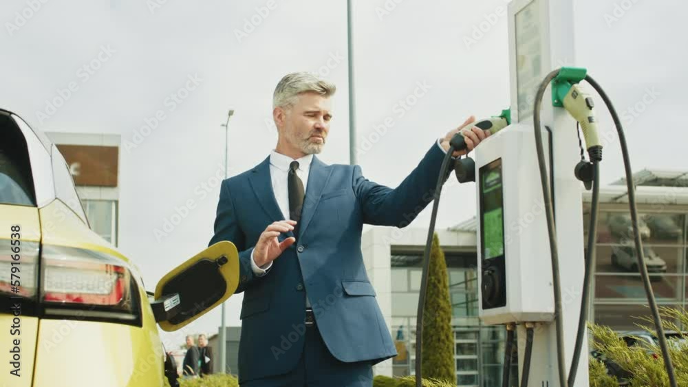 Vídeo do Stock Charging electric car at charging station. Businessman