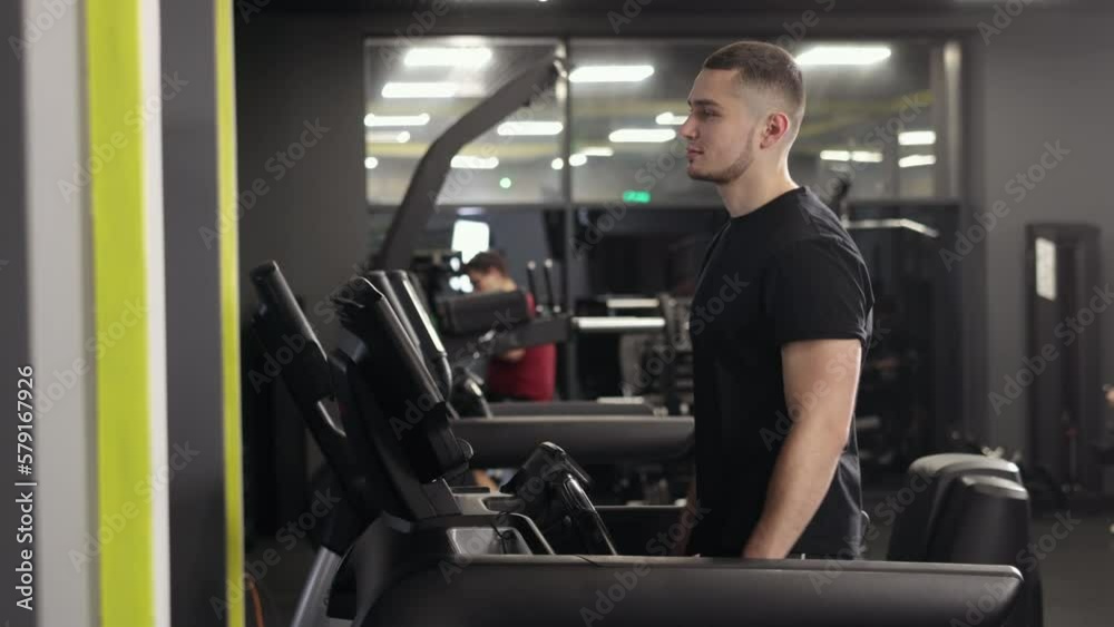 Gym treadmill, Endurance training, Fitness tracker. The man is running on a treadmill at the gym. Gym treadmill, Endurance training, Fitness tracker. The man is running on a treadmill at the gym.
