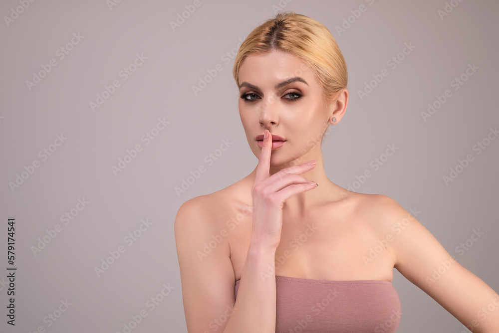 Woman asking for silence and quiet, gesturing with finger in front of mouth, saying shh, keeping a secret. Girl on studio background asking to be quiet with finger on lips. Silence and secret. Woman asking for silence and quiet, gesturing with finger in front of mouth, saying shh, keeping a secret. Girl on studio background asking to be quiet with finger on lips. Silence and secret.
