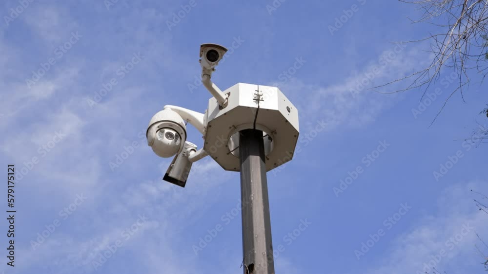 complex of surveillance cameras installed on pole in city park or city center against blue sky with clouds. Round-the-clock monitoring of people, life under the hood. complex of surveillance cameras installed on pole in city park or city center against blue sky with clouds. Round-the-clock monitoring of people, life under the hood.