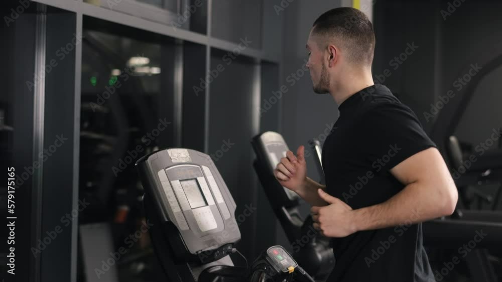 Leg muscles, Body toning, Treadmill speed. The young man is getting his exercise by running on a treadmill. Leg muscles, Body toning, Treadmill speed. The young man is getting his exercise by running on a treadmill.