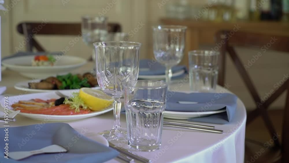 Served tables for a holiday in a restaurant. Glasses, plates, cutlery, napkins. Wedding decor, celebration dinner or party, reception indoors. No food. Served tables for a holiday in a restaurant. Glasses, plates, cutlery, napkins. Wedding decor, celebration dinner or party, reception indoors. No food.