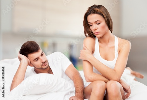 Sad young couple posing at home