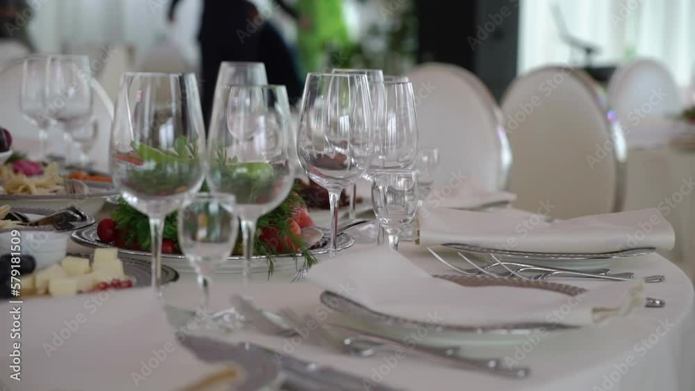 Served tables for a holiday in a restaurant. Glasses, plates, cutlery, napkins. Wedding decor, celebration dinner or party, reception indoors. No food. Served tables for a holiday in a restaurant. Glasses, plates, cutlery, napkins. Wedding decor, celebration dinner or party, reception indoors. No food.
