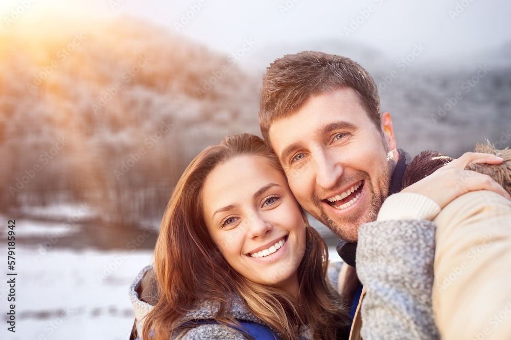 Happy young couple enjoying and posing on winter background Happy young couple enjoying and posing on winter background