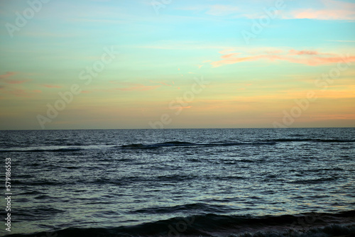Ocean sunset landscape with soft evening sea water waves crushing on sandy beach © bilanol