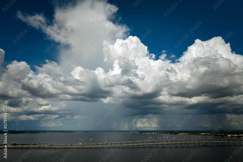 Stormy clouds forming from evaporating humidity of ocean water before thunderstorm over traffic bridge connecting Punta Gorda and Port Charlotte over Peace River. Bad weather conditions for driving Stormy clouds forming from evaporating humidity of ocean water before thunderstorm over traffic bridge connecting Punta Gorda and Port Charlotte over Peace River. Bad weather conditions for driving