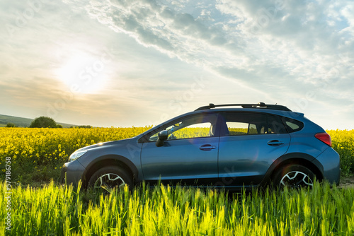 Subaru Crosstrek car at sunrise on farmland field. Traveling by auto, adventure in wildlife, expedition or extreme travel on SUV. Offroad 4x4 vehicle under clear morning sun