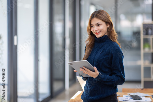 portrait of young asian woman, company worker at workplace, smiling and holding digital tablet, standing over office background Free Download portrait of young asian woman, company worker at workplace, smiling and holding digital tablet, standing over office background - GFXLoad