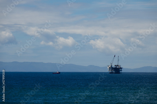 California coast with an offshore oil rig and cranes