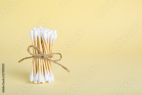 Bunch of wooden cotton buds on beige background. Space for text