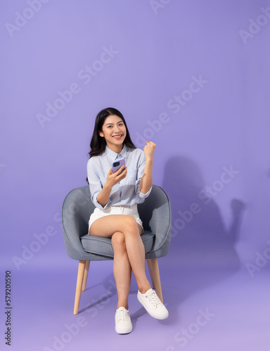 image of girl sitting on sofa isolated on purple background