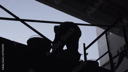 Silhouette of construction worker with cement trowel