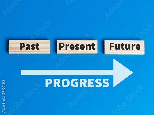 Past present and future time progress concept on wooden blocks against blue background.