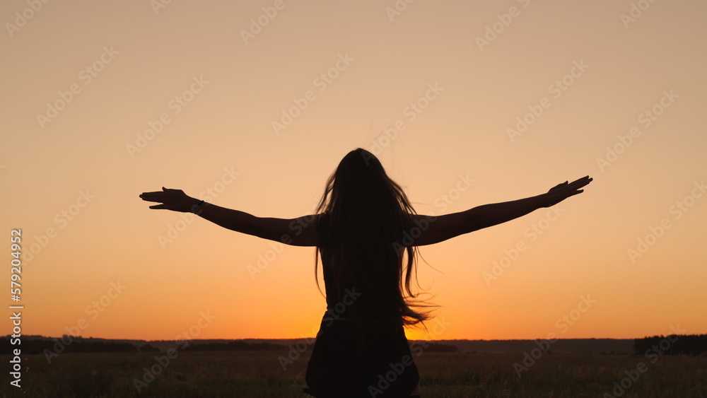 Young woman goes in for sports in park at sunset. Healthy girl is engaged in fitness, outside city in sun. Workout and warm-up in fresh air. Girl is engaged in gymnastics. Athlete exercising in nature