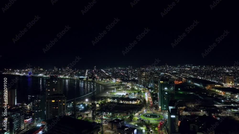 Aerial establishing shot of the crowded downtown Iquique at night with bright lights Aerial establishing shot of the crowded downtown Iquique at night with bright lights