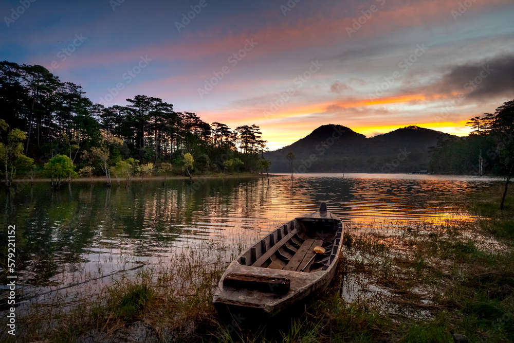 Fototapeta premium A lonely boat during a beautiful sunset and nice reflection