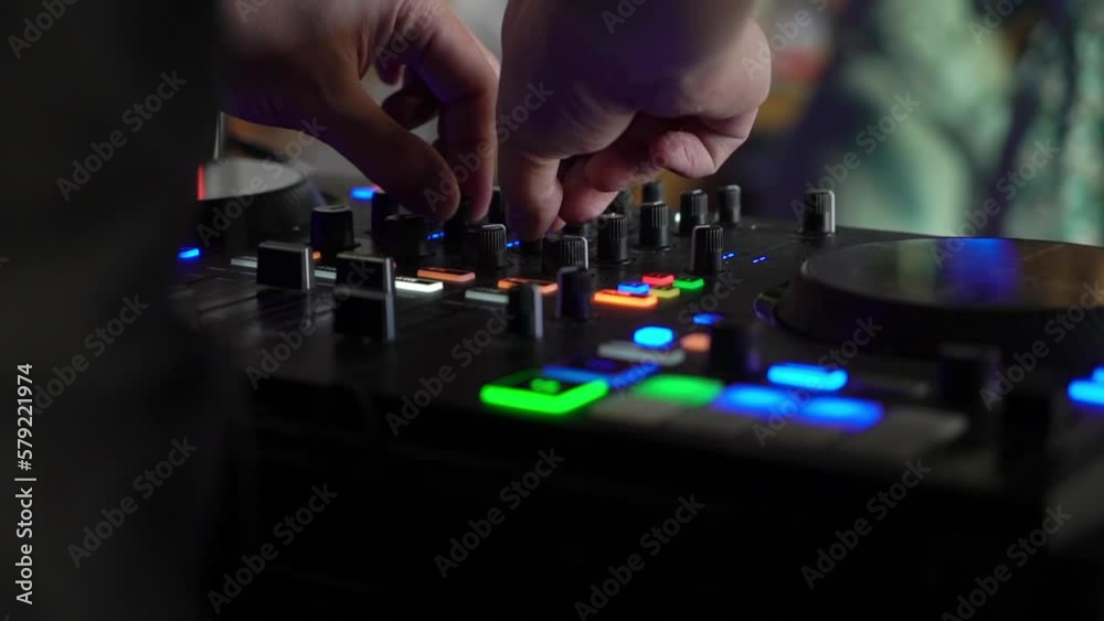 Professional sound console, DJ mixer. Close-up equipment for a concert, party in a nightclub. Disc jockey plays music, people dance in the background. Professional sound console, DJ mixer. Close-up equipment for a concert, party in a nightclub. Disc jockey plays music, people dance in the background.
