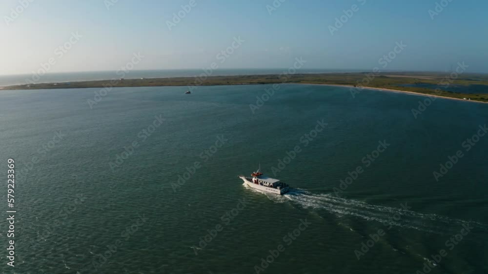 Aerial drone pull away of fishing boat leaving harbor and heading out to see in South Padre Texas on hot summer day Aerial drone pull away of fishing boat leaving harbor and heading out to see in South Padre Texas on hot summer day