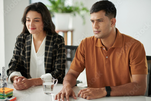 Married young couple visiting bank manager to discussing mortgage