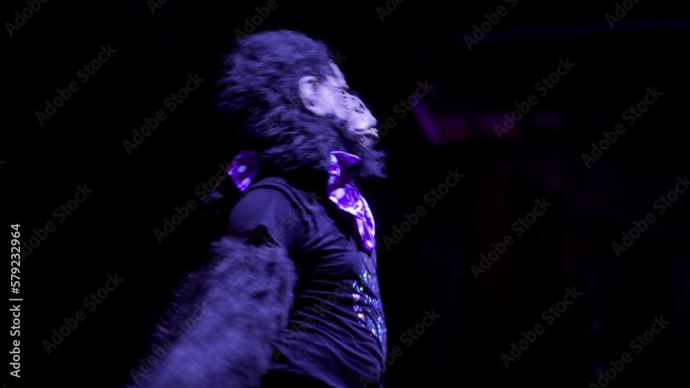 A performer in gorilla costume dancing in front of a crowd in a club A performer in gorilla costume dancing in front of a crowd in a club