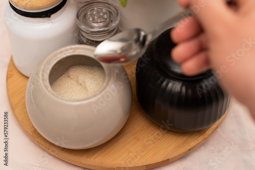 Hand taking suger from decoration mug