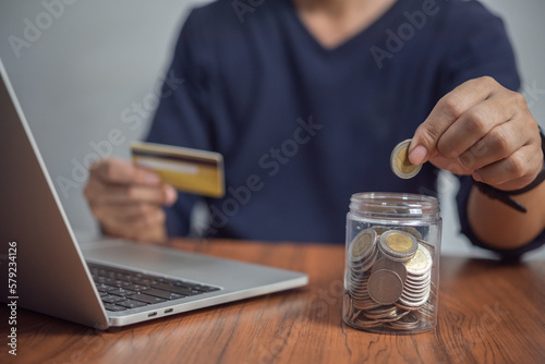 Man putting coin in jar. investment and money saving, banking and finance, online shopping on the internet, accounting and tax Business concept.