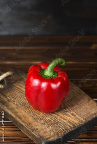 red fresh ripe paprika on wooden board