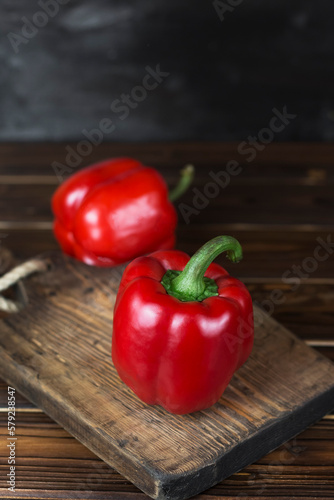 red fresh ripe paprika on wooden board