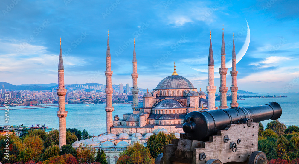 Obraz premium Ramadan Concept - Sultanahmet mosque and Bosphorus with crescent moon and cannon at twilight blue hour - Istanbul, Turkey