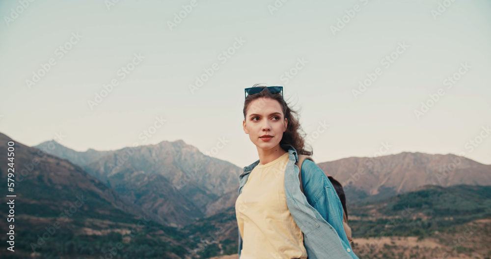 Naklejka premium Portrait of beautiful girl enjoying fresh air at the mountains. Beautiful natural woman looking at copy space, freedom concept