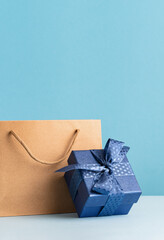 small Luxury gift box with a blue bow paper bag and agenda. Side view. Fathers day or Valentines day gift for him. Corporate gift concept or birthday party. Festive sale copy space