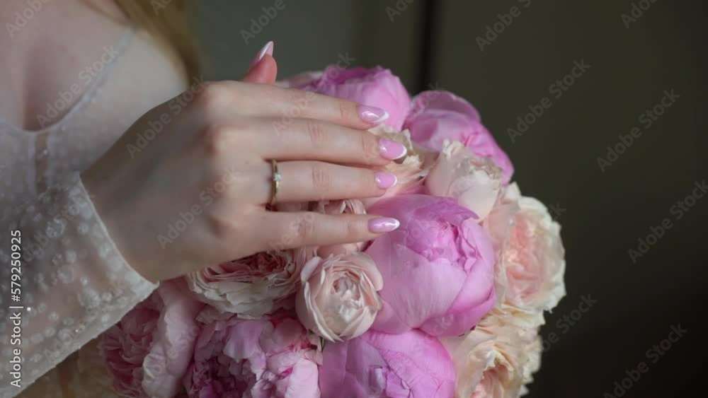 Female in dress hold in hands bouquet with ribbons of pink peony flowers. Gift for a woman, holiday, wedding bouquet of the bride. Floristics in summer. Bride in wedding day. Female in dress hold in hands bouquet with ribbons of pink peony flowers. Gift for a woman, holiday, wedding bouquet of the bride. Floristics in summer. Bride in wedding day.