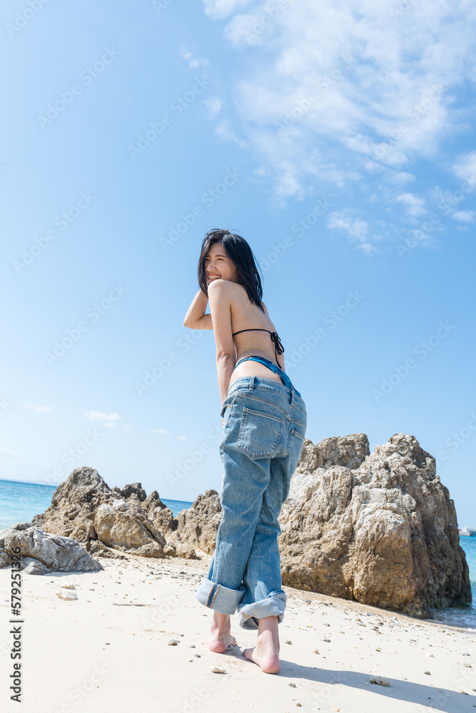 Naklejka premium 沖縄のビーチでビキニポートレートを撮る女性