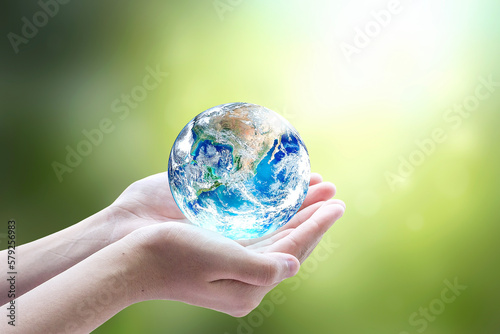 Fototapeta Naklejka Na Ścianę i Meble -  Human hands holding earth globe over blurred green nature background. Elements of this image furnished by NASA
