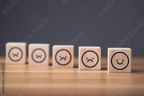 Emotional state concept. Sad face to smile face on wooden blocks cube arranged on wooden table. Idea of manythink to face and smile in finally.