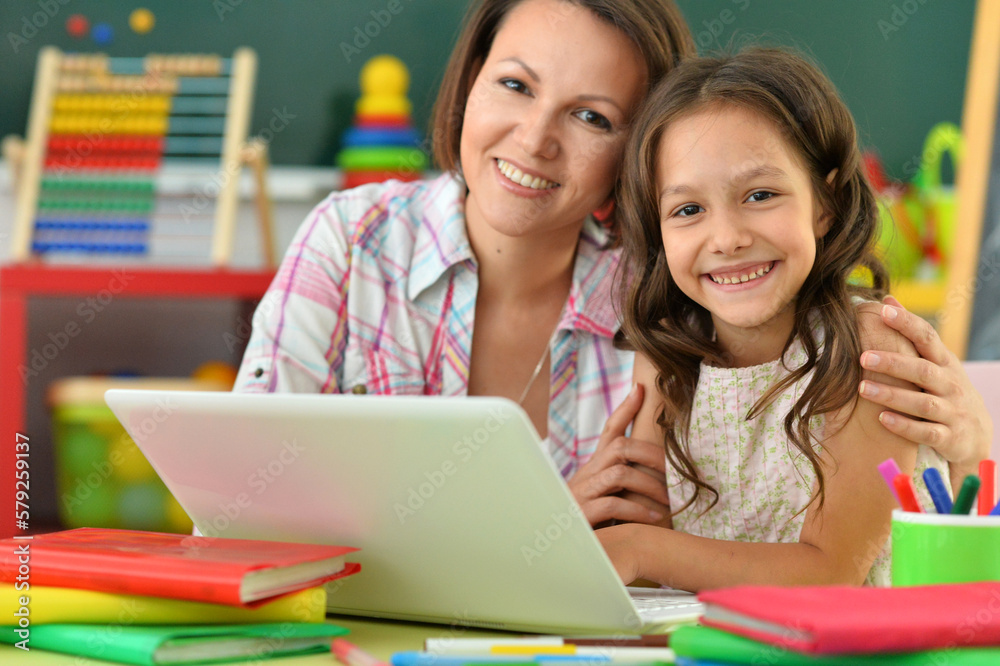 portrait of mother and daughter using laptop portrait of mother and daughter using laptop