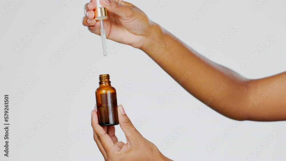 Closeup, hands and pipette for skincare, cosmetics and dermatology against a grey studio background. Zoom, hand and bottle with serum, collagen and oil for treatment, grooming and product for beauty Closeup, hands and pipette for skincare, cosmetics and dermatology against a grey studio background. Zoom, hand and bottle with serum, collagen and oil for treatment, grooming and product for beauty