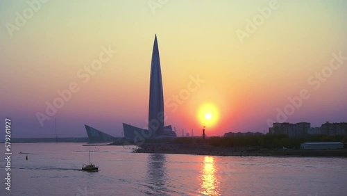 Modern skyscrapper silhouette against clear sunset sky. Tallest building in Europe as for 2021. Calm water of Bay on foreground