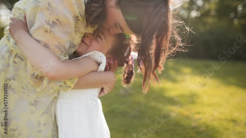 Happy cute girl runs to mother, with eyes closed charming little baby daughter hugs mom, hugs, enjoys tender sweet moment concept, close up.  Family walking in the park in nature