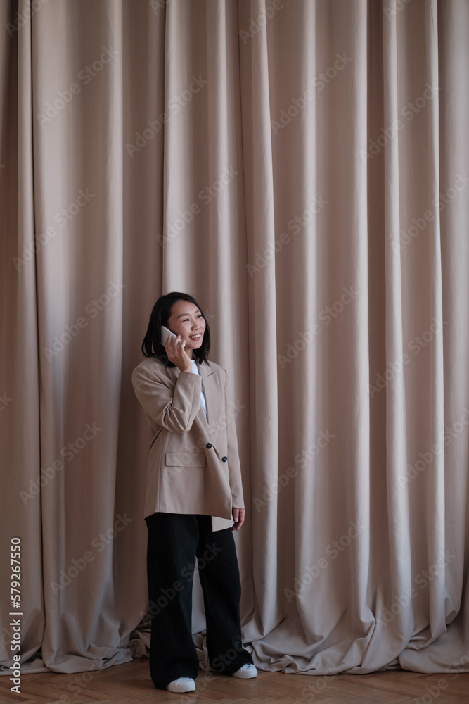 Portrait of a happy asian businesswoman using mobile phone
