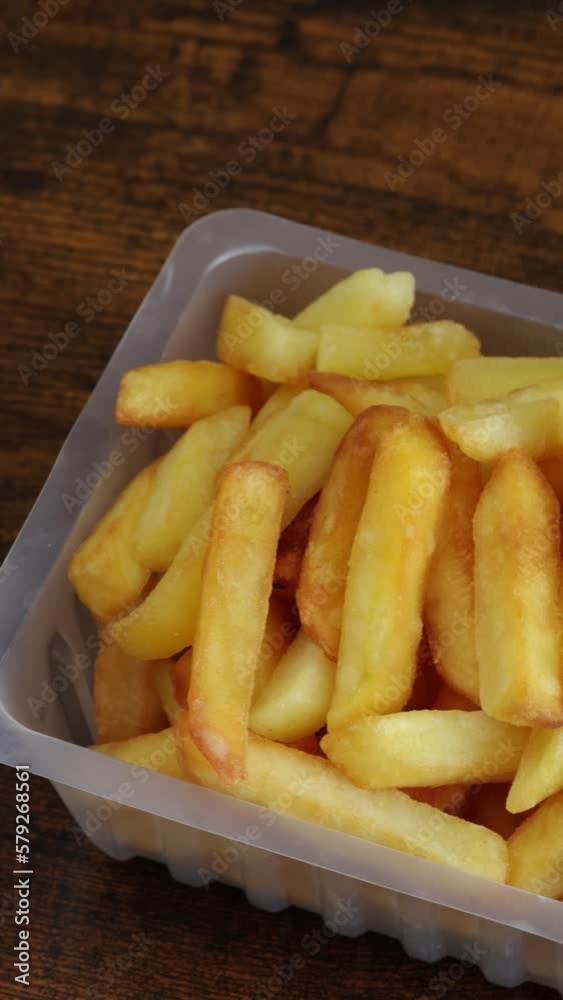 barquette de frites, en gros plan, sur une table barquette de frites, en gros plan, sur une table