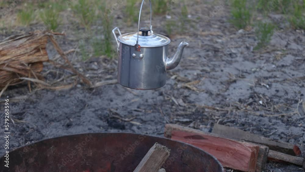 A close up of a traditional Australian billy boiling over the campfire.