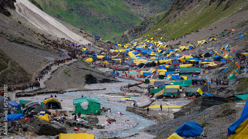 AMARNATH, JAMMU and KASHMIR, INDIA, JULY 06, 2022: Holy Amarnath Cave in Kashmir Himalayas. It is a Hindu shrine dedicated to Shiva. It is one of the holiest shrines in India. Selective focus.
 photo