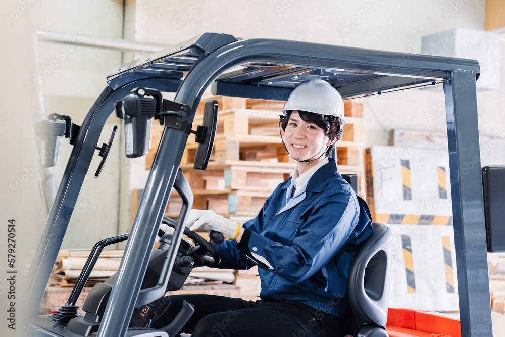 Naklejka premium 現場でフォークリフトを運転する男性作業員