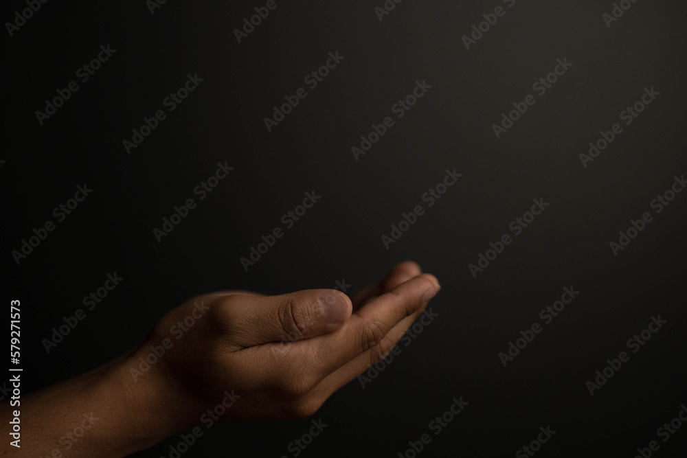Praying hands with faith in religion and belief in God on dark background. Power of hope or love and devotion. Praying hands with faith in religion and belief in God on dark background. Power of hope or love and devotion.